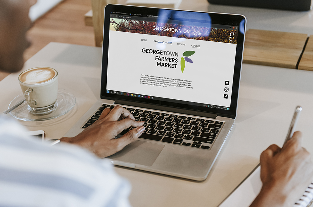 .image of a woman viewing the webpage of georgetown farmers market